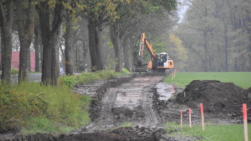 Der Bagger trägt den Oberboden für den neuen Radweg an der L123 ab.