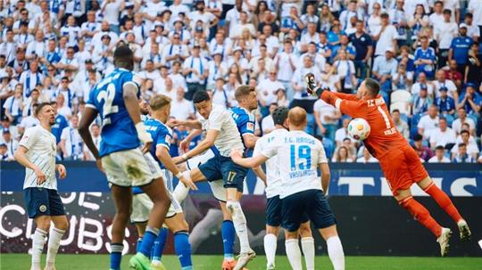 Der Ball fliegt an Hansa-Torwart Markus Kolke (r) zum 2:1 für Schalke vorbei.