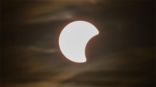 Der Beginn einer partiellen Sonnenfinsternis ist am Himmel über Dresden zu sehen.