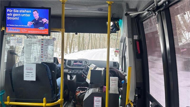 Der Bürgerbus fährt den verschneiten Waldweg hinauf.