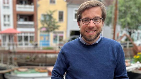 Der Bundestagsabgeordnete Victor Perli macht Europawahlkampf für die Partei Die Linke in Buxtehude. Das Foto entstand am Fleth der Hansestadt Buxtehude.