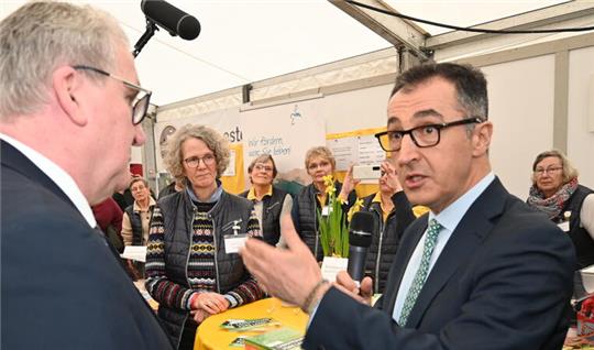 Der Bundesvorsitzende der Fachgruppe Obstbau, Jens Stechmann (links), im Gespräch mit Bundeslandwirtschaftsminister Cem Özdemir (Grüne) auf der Obstbaumesse am Stand der Altländer Landfrauen.