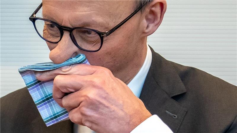Der CDU-Vorsitzende Friedrich Merz putzt sich die Nase.