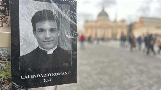 Der „Calendario Romano“ an einem Souvenirstand, im Hintergrund der Petersdom.