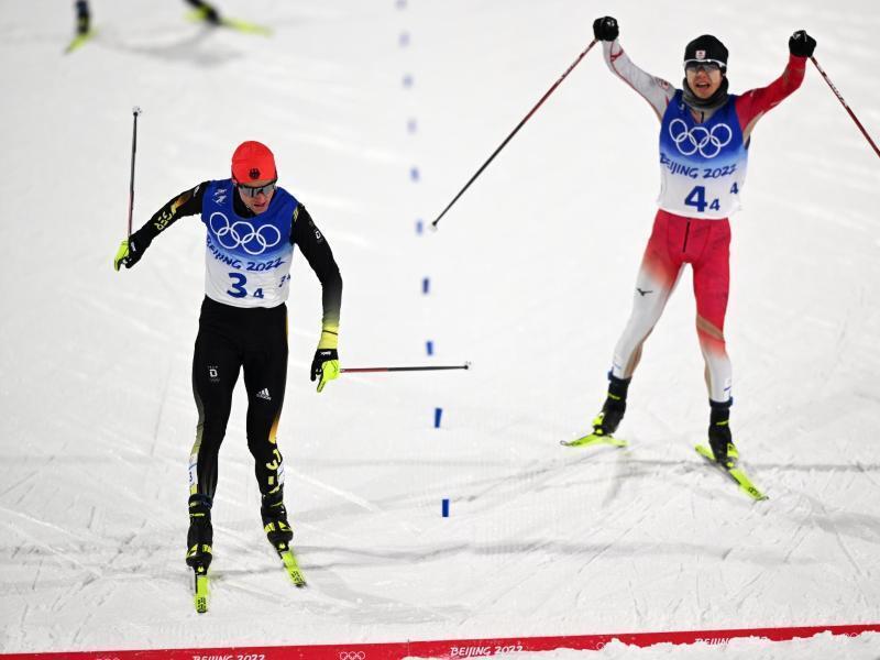 Der DSV-Kombinierer Vinzenz Geiger (links) überquert vor Ryota Yamamoto aus Japan die Ziellinie. Foto: Hendrik Schmidt/dpa