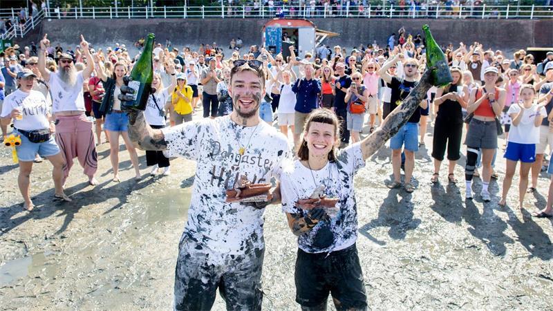 „Watt en Schlick“ geht mit Wettrutschen im Watt zu Ende Der „Dangaster Hüne“ (l) und „Üffes“ feierten ihren Sieg mit Sekt.