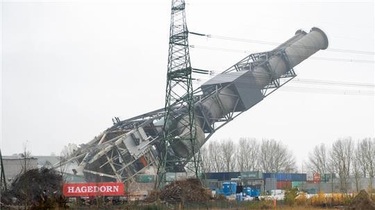 Der Doppel-Schornstein des stillgelegten Kohlekraftwerks Moorburg kippt nach seiner Sprengung um.