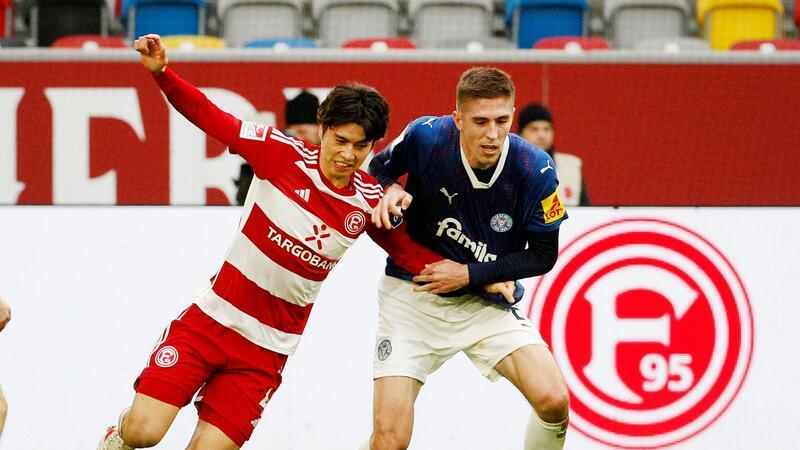 Der Düsseldorfer Ao Tanaka (l) und der Kieler Marko Ivezic kämpfen um den Ball.