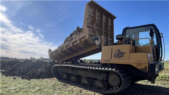 Der Dumper kippt den Boden zu Vorbelastung der Deichtrasse am Ilsmoorbach ab.