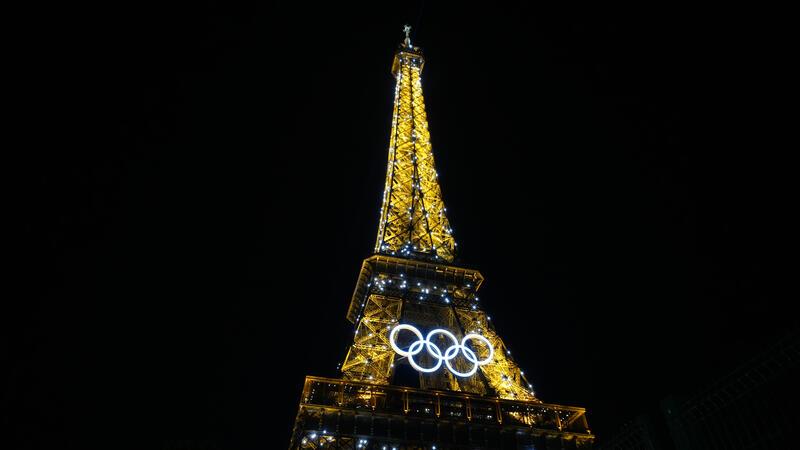 Pariser Eiffelturm während Olympia bei Nacht.