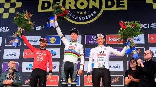 Der Erstplatzierte Mathieu van der Poel (M) aus den Niederlanden feiert auf dem Podium mit dem Zweitplatzierten Luca Mozzato (l) aus Italien und Nils Politt.