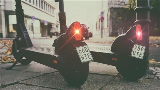 E-Scooter stehen auf einer Straße (Symbolbild).