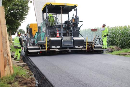 Der Fertiger verteilt den etwa 170 Grad heißen Asphalt auf der Tragschicht. Fotos: Klempow