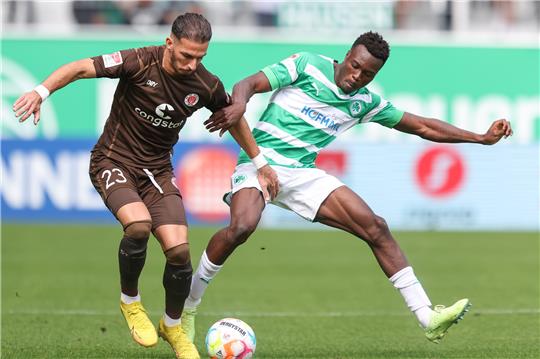 Der Fürther Dickson Abiama (r) kämpft mit Leart Paqarada vom FC St. Pauli um den Ball. Foto: Daniel Karmann/dpa