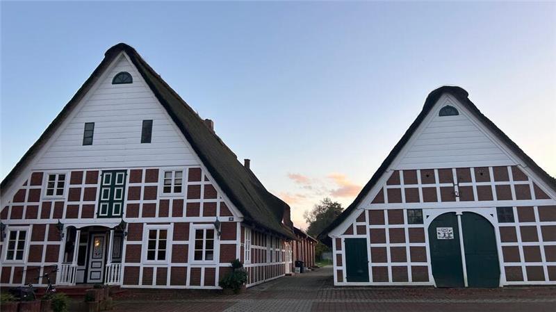 Gasthaus als Familiensache: Neustart im Großenwördener Hof Zwei Fachwerkhäuser mit Reetdach nebeneinander. Das größere Haus steht links und ist das Gasthaus Großenwördener Hof. Im Gebäude rechts ist die Deckstelle des Landgestüts untergebracht.