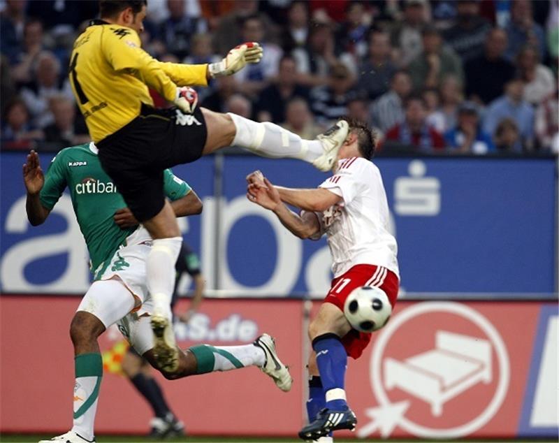 Der Hamburger Ivica Olic und der Bremer Torwart Tim Wiese kämpfen um den Ball. Foto: picture alliance/dpa