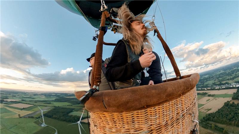 Der Hamburger Musiker Johannes "Johnny" Ritter spielt im Korb eines Heißluftballons 327 Meter über dem Festivalgelände des Wacken Open Air (WOA) ein Luftgitarren-Solo. Foto: Haribo GmbH &amp; Co KG/dpa
