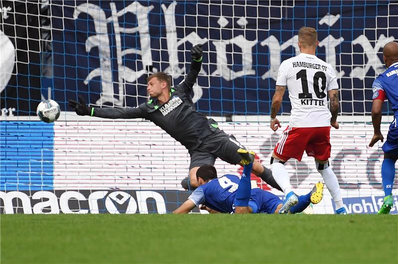 Der Hamburger Sonny Kittel (r) erzielt den Treffer zum 0:2. Der Karlsruher Torwart Benjamin Uphoff kann den Ball nicht halten. Foto: Uli Deck/dpa