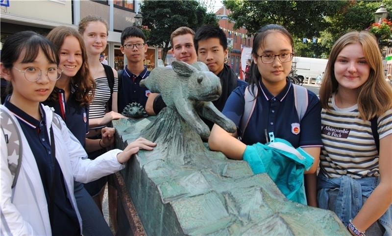 Der Has’ und Igel-Brunnen ist für diese Gruppe chinesischer Schüler mit ihren Buxtehuder Austauschpartnern eine Station der Stadtrallye. Foto: Richter