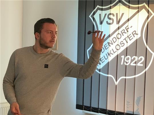 Der Hedendorfer Fußballer Jerome Kröger weiht eines der neuen Dartspielfelder im VSV-Treff ein. Foto: Stahmann