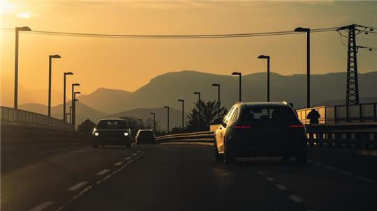 Ein Auto steht morgens an einer Straße.