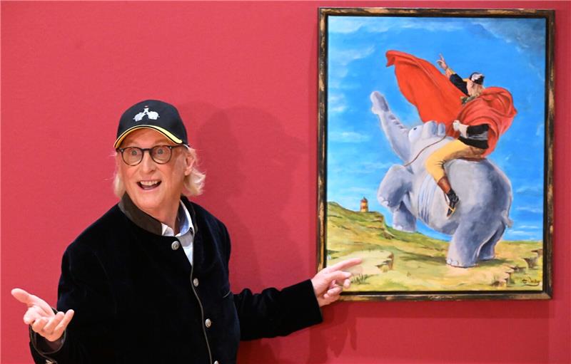 Der Komiker und Künstler Otto Waalkes steht beim Presserundgang durch "Otto die Ausstellung" von Otto Waalkes im Buchheim Museum vor dem Bild "Der Napoleotti bei der Überquerung des Münchner Hochplateaus zum Buchheim Museum, 2023" von Otto Waalkes. Foto: Felix Hörhager/dpa