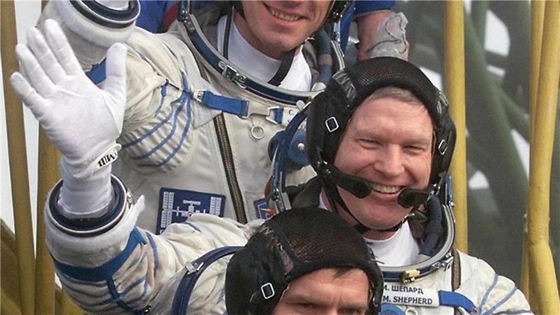 „Unwahrscheinlichste Maschine“: 25 Jahre Crew auf der ISS Der Kommandant der ersten Langzeitmission zur Internationalen Raumstation, der amerikanische Astronaut Bill Shepherd (M), und die russischen Kosmonauten Juri Gidsenko (unten) und Sergej Krikaljow (oben) winken, bevor sie auf dem Kosmodrom in das Raumschiff „Sojus-TM-31“ einsteigen. (Archivbild)