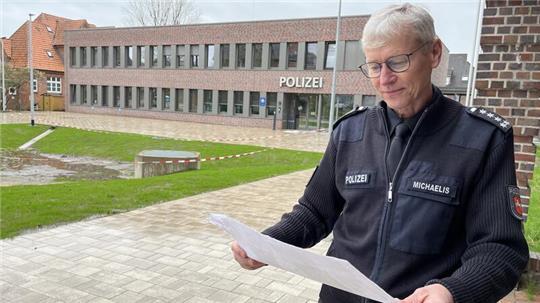 Der Leiter des Einsatz- und Streifendienstes der Polizeiinspektion Stade, Ralf Michaelis, studiert vor der neuen Wache in der Teichstraße die Pläne für die Außenanlagen.