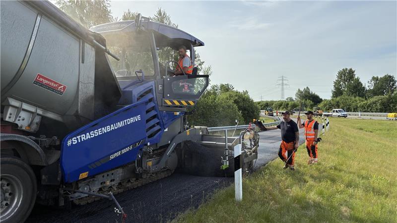 Darum muss der Asphalt auf der A26 saniert werden Der Lkw-Fahrer kippt Asphalt in den Fertiger.