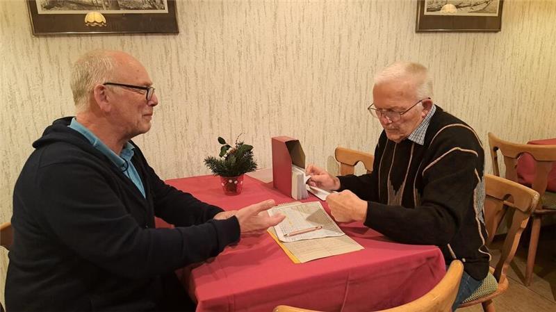 Der Mann mit den Umschlägen: Günther Heine (rechts) vom Sparclub bei Mensing zahlt zum letzten Mal die Ersparnisse an Klaus Aschen aus