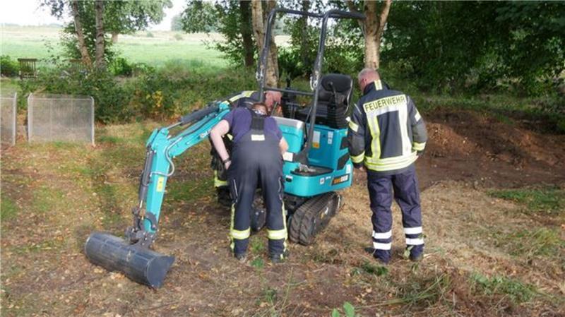 Minibagger kippt um: Mann verletzt sich schwer Feuerwehrleute untersuchen einen Minibagger in Kleinwörden, Gemeinde Hechthausen.