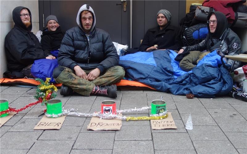 Der Obdachlose Chris (rechts) und seine Freunde sitzen vor einem Hauseingang in Hamburg. Foto Dördrechter/dpa