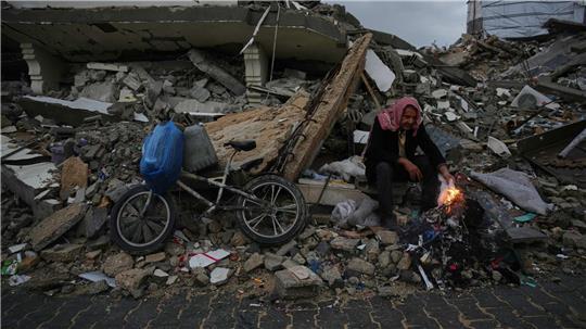 Der Palästinenser Mohammed al-Jabri, 58, wärmt sich neben einem Feuer, während er auf den Trümmern eines Gebäudes sitzt, das während der israelischen Luft- und Bodenoperationen im Viertel Sheikh Radwan zerstört wurden.