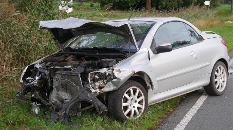 Der Peugeot 206 CC steht nach dem schweren Unfall stark beschädigt am Fahrbahnrand.