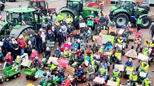 Der Platz vor dem Deutschen Haus in Mulsum ist gefüllt: Rund 60 Kinder mit Trettreckern machen sich anschließend auf die Runde durch den Ort. Vorweg und hinterher fahren die großen Schlepper.