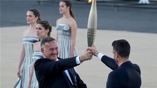 Der Präsident des französischen Organisationskomitees, Tony Estanguet (r), nahm die olympische Flamme in Athen entgegen.