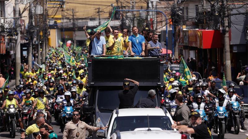 Der Präsidentschaftskandidat der Opposition, Flavio Bolsonaro (Mitte 2.v.l), begrüßt seine Anhänger während einer Wahlkampfveranstaltung im Vorfeld der bevorstehenden Stichwahl um das Präsidentenamt.