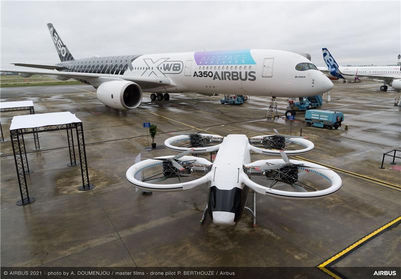 Der Prototyp des City Airbus vor einem Airbus A350 auf dem Rollfeld in Toulouse.