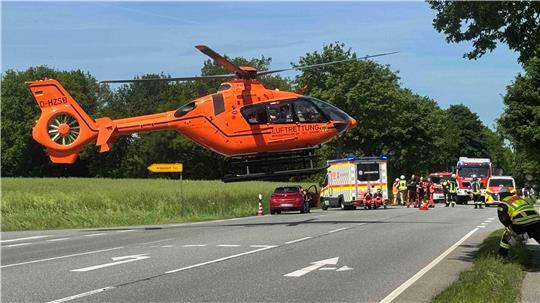 Der Radfahrer muss per Helikopter ausgeflogen werden. Die Feuerwehr sichert die Straße.