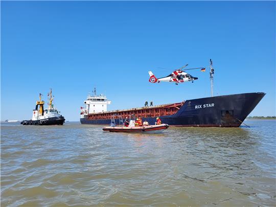 Der Rettungshubschrauber 'Northern Rescue 01' und Motorrettungsboot 'RuekUt' am Cargoschiff. Fotos: DLRG