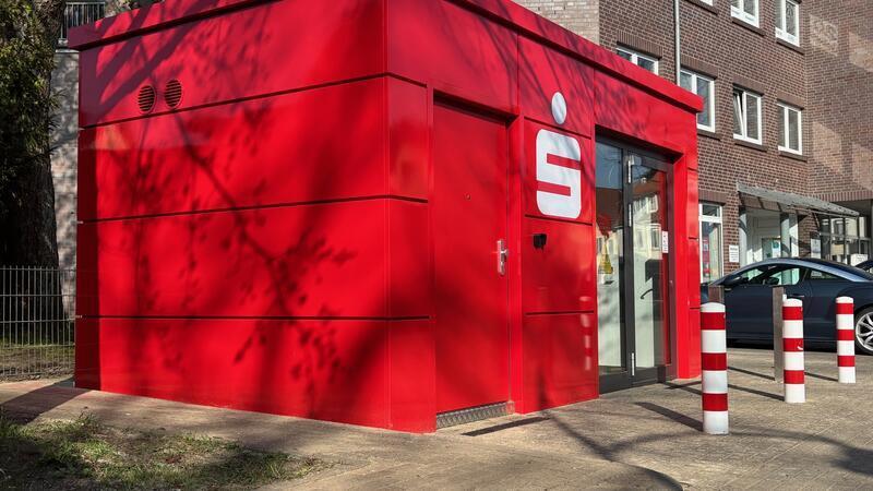 Der SB-Pavillon der Sparkasse Harburg-Buxtehude befindet sich auf dem Parkplatz neben der inzwischen geschlossenen Filiale (Gebäude rechts) an der Hauptstraße in Altkloster.