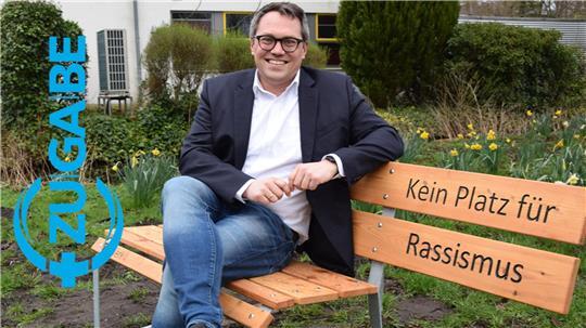 Prominenter erster Gast auf der Bank gegen Rassismus in Buxtehude: Der Europaparlamentarier Tiemo Wölken (SPD) nimmt auf der von der Awo initiierten Sitzgelegenheit am Genslerweg Platz.
