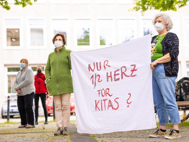 Der Schriftzug «Nur 1/2 Herz für Kitas?» ist auf einem Transparent bei einer Demonstration von Erziehern vor dem niedersächsischen Landtag zu lesen. Foto: Moritz Frankenberg/dpa