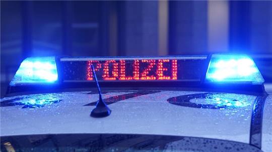Der Schriftzug „Polizei“ ist neben dem Blaulicht auf dem Dach eines Polizeiautos zu lesen.