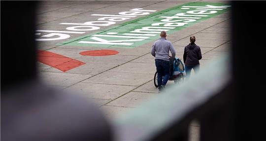 Der Schriftzug aus Kreidefarbe ist insgesamt rund 50 Meter lang und soll auf den nächsten Klimastreik der Bewegung Fridays for Future (FFF) im September aufmerksam machen. Foto: Julian Weber/dpa