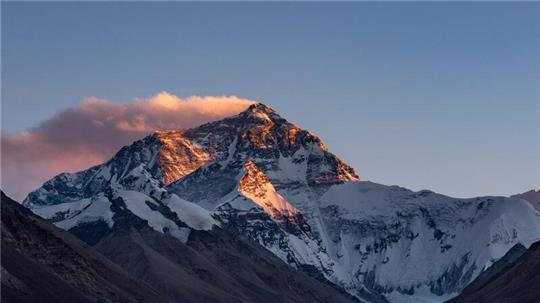 Der Sonnenuntergang färbt den Gipfel des Mount Everest.