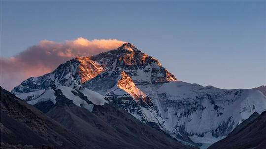 Der Sonnenuntergang färbt den Gipfel des Mount Everest.