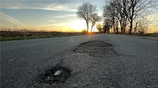 Schlaglöcher im Hagener Weg in Dollern während eines Sonnenuntergangs.