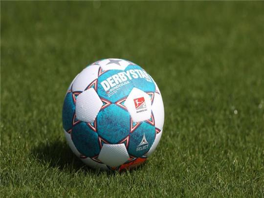 Der Spielball liegt auf dem Rasen. Foto: Guido Kirchner/dpa/Symbolbild