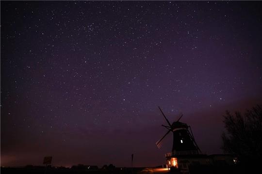 Der Sternenhimmel ist über der Nordermühle auf der Insel Pellworm zu sehen. Foto: Marcus Brandt/dpa